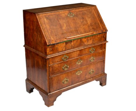 A George II walnut bureau banded in herringbone, the fall front enclosing a fitted interior of pigeon holes and drawers, with