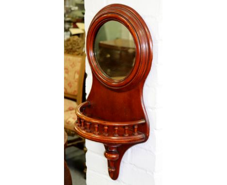 A circular wall mirror with galleried shelf below, 64cm high