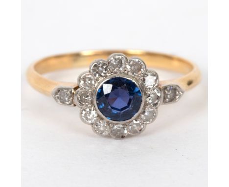 A sapphire and diamond cluster ring flanked by a diamond to each shoulder, set in platinum and 18ct yellow gold, size N