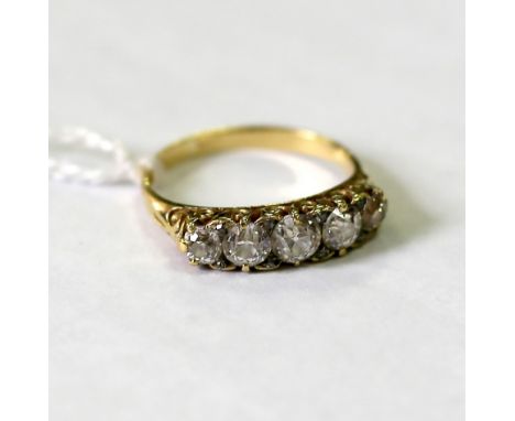 An Edwardian five-stone diamond ring, the graduated stones in a yellow gold scroll setting, size O