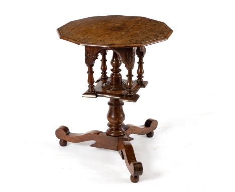 A pollard oak revolving centre table, the moulded dodecagonal top on turned baluster shaft flanked by turned baluster arches 