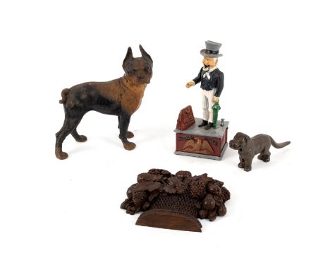 A carved wood relief, basket of fruit, a dog nutcracker, a reproduction moneybox, Uncle Sam and a cast model of a dog