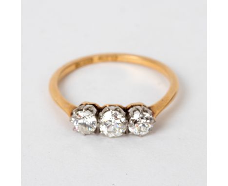 A diamond three-stone ring, the stones set in platinum to an 18ct yellow gold shank, size O