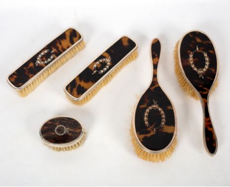 A tortoiseshell backed dressing set of five pieces, Birmingham 1921 and an engine turned comb case, Birmingham 1941