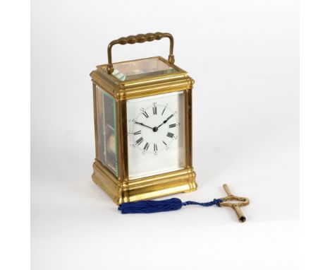 A gilt brass eight-day carriage clock with white enamel dial and movement striking on a gong, 18cm high
