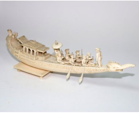 An Indian carved ivory model, Company School, 19th Century depicting a pleasure boat with seated figures rowing, the boat wit