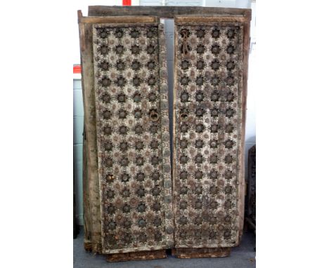 A pair of carved and brass studded doors with iron ring handles, 180cm x 59cm and the frieze for the same