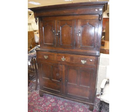 A 18th Century Lake district oak court cupboard, the upper section with moulded cornice over three doors one fitted with two 
