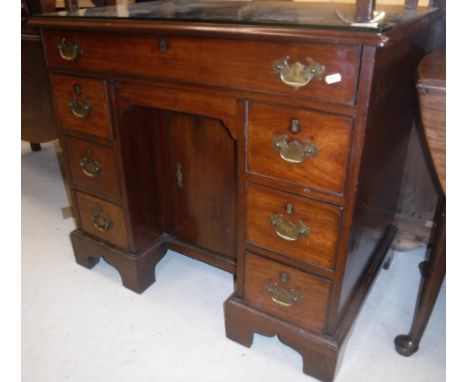 A late George III mahogany kneehole desk, the top with moulded edge over a single long drawer (formerly a secretaire drawer),