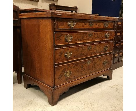 A burr walnut bachelor's chest in the early 18th Century manner, the fold-over top quartered, feathered and crossbanded with 