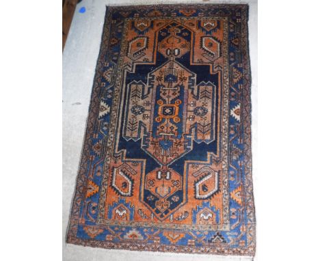 A Persian rug with architectural style centre medallion on a blue ground, within oxide red spandrels with leaf decoration and