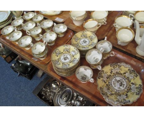 Two trays of 19th Century English porcelain teaware on a white and yellow ground, with gilt floral and foliate decoration, co