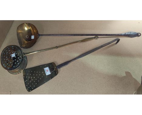 A 19th century cream skimming ladle in brass and wrought iron; a similar slice; an oval chestnut roaster 