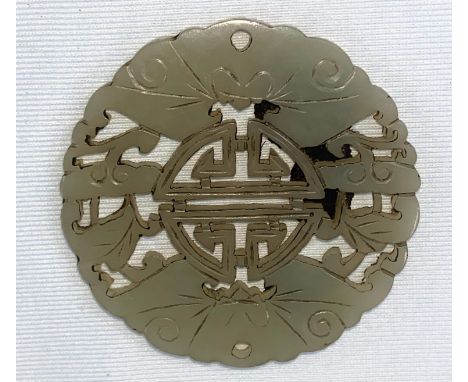 A small Chinese jade coloured hardstone circular item with pierced decoration, diameter 6cm.&nbsp;&nbsp;Possibly a furniture 