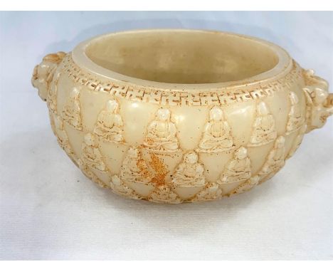 A Chinese white jade coloured hardstone bowl decorated with seated buddhas in relief, diameter 15cm.&nbsp; There is staining 