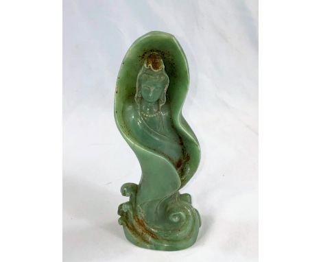 A Chinese jade coloured hardstone figure of a deity wrapped in a naturalistic form of leaf or wave, height 20cm.&nbsp; Some s