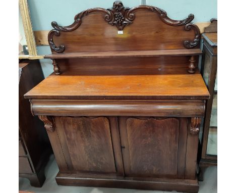 A Victorian figured mahogany chiffonier with carved arched  back and raised shelf over frieze drawer and double cupboard, pli