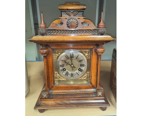 An Edwardian mantel clock in stained walnut architectural case with turned finials, brass dial and striking movement, height 