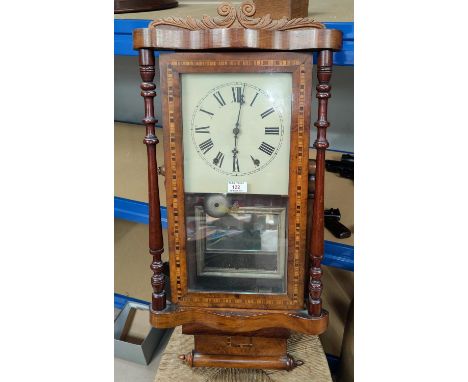 A 19th century American wall clock in walnut case with Tunbridge style inlay, scrolled crest and turned side columns, strikin