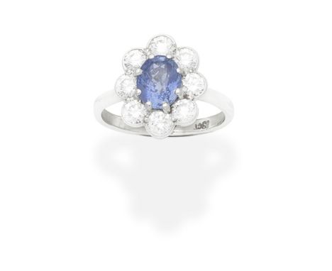 SAPPHIRE AND DIAMOND CLUSTER RINGThe oval-cut sapphire within a brilliant-cut diamond surround, diamonds approx. 0.80ct total
