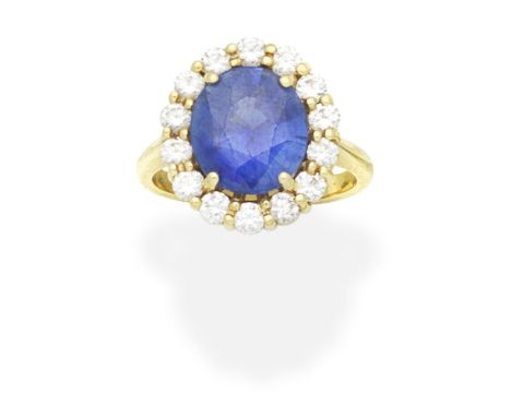 SAPPHIRE AND DIAMOND CLUSTER RINGThe circular-cut sapphire within a brilliant-cut diamond surround, mounted in 18 carat gold,