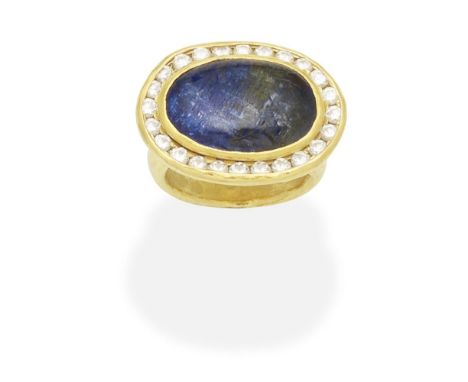 SAPPHIRE AND DIAMOND RINGThe oval sapphire cabochon within a brilliant-cut diamond surround within closed-back settings, the 