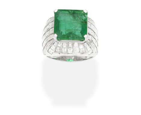 EMERALD AND DIAMOND DRESS RINGThe step-cut emerald within a baguette-cut diamond-set mount,  one diamond deficient, diamonds 