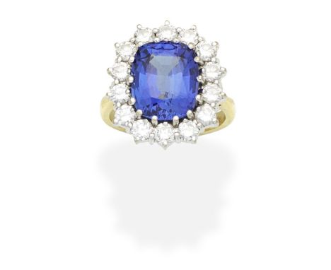 TANZANITE AND DIAMOND CLUSTER RINGThe cushion-shaped tanzanite, weighing 6.40 carats, within a surround of brilliant-cut diam