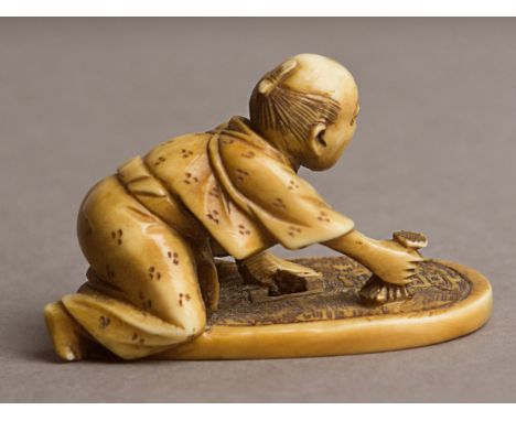 A 19th century Japanese netsuke from Meiji period. Signed on a side.In carved elephant ivory portraying a kneeling man over a