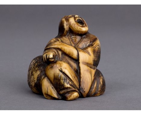 A 19th century Japanese netsuke from Edo period. Not signed. In carved elephant ivory portraying a male character kneeled nex