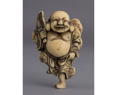 A 19th century Japanese netsuke from Meiji period. Not signed. In carved elephant ivory portraying Hotei dancing on one of hi