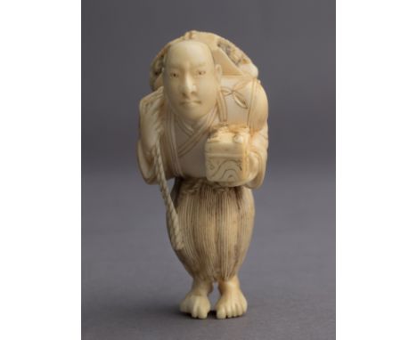 A 19th century Japanese netsuke from Meiji period. Not signed. In carved elephant ivory portraying a man carrying a turtle ov