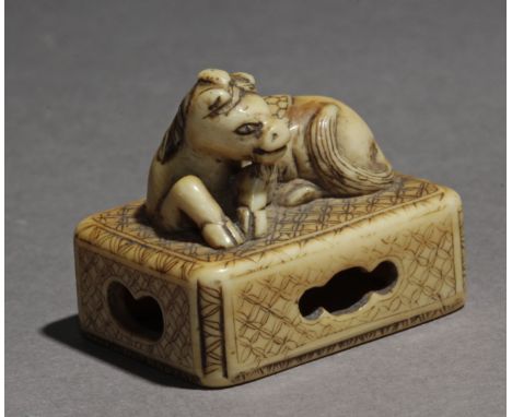 An early 19th century Japanese netsuke from Edo period. Not signed. In carved elephant ivory portraying a recumbent Suisei, l