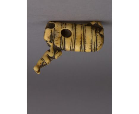 An 18th century Japanese netsuke from Edo period. Not signed. In carved elephant ivory portraying a man carrying over his sho