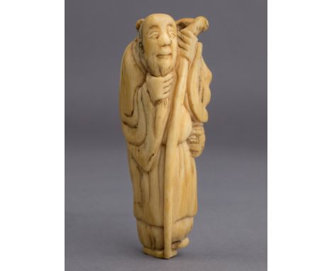 An 18th century Japanese netsuke from Edo period. Not signed. In carved elephant ivory portraying a standing Sennin with his 