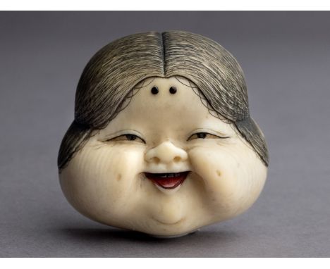 A 19th century Japanese netsuke from Meiji period. Signed on the back. In carved elephant ivory portraying a smiling Okame ma