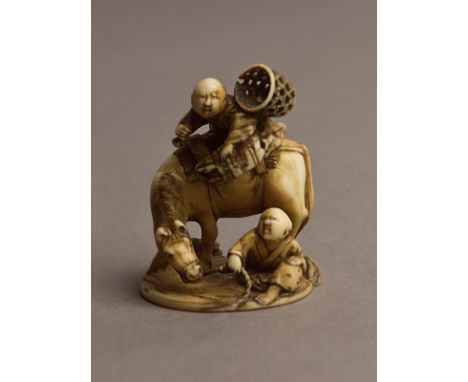 A 19th century Japanese netsuke from Meiji period. Signed Tomochika on the base. In carved ivory portraying a group of figure