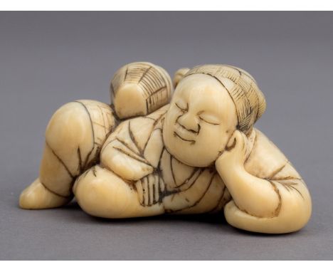 A 19th century Japanese netsuke from Meiji period. Not signed. In carved elephant ivory portraying a man sleeping on the floo