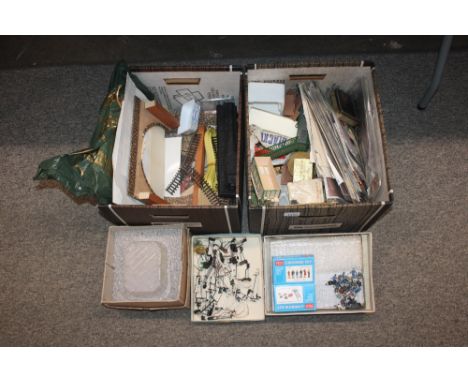 Two boxes of model railway building components to include track, fencing, ballast, spare figures, part buildings etc.