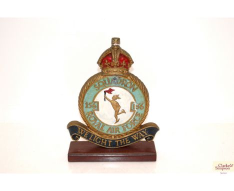 A WWII era cast plaque mounted on wooden plinth. The plaque for Royal Air Force 156 Squadron (We Light The Way) 