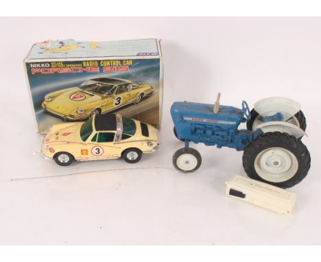 A Nikko boxed Porsche 9115 radio controlled car with a small amount of blue Lego and a model Ford tractor