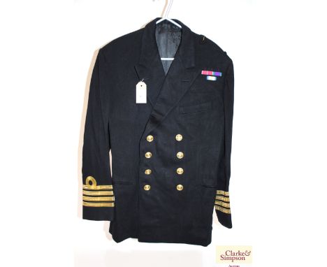 A Royal Navy jacket, tailors label to R. McQueen, insignia for a Captain and medal ribbons in place