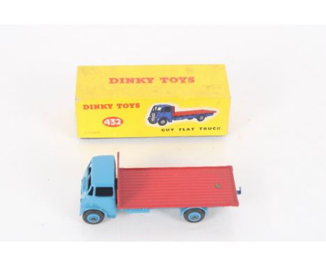 A Dinky Toys number 432 Guy flat truck, blue cab and chassis, having red back and light blue hubs, yellow and blue box