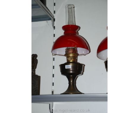 A Brass Oil Lamp with red shade and funnel