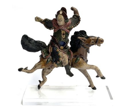 A Chinese polychrome glazed ceramic figural roof tile modelled as a warrior on horseback, 30cm high, mounted on a perspex pli