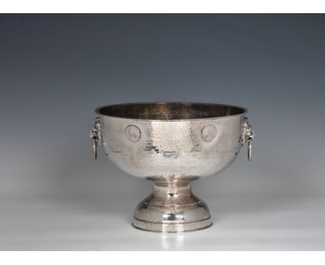 A silver plate on copper pedestal punch bowl, with planished decoration with twin lion mask and ring handles and applied Geor