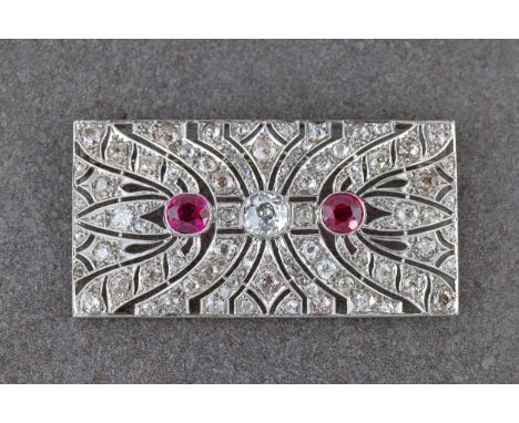 A fine Art Deco platinum, diamond and synthetic ruby plaque brooch, 1930s, the rectangular panel with a central principal old