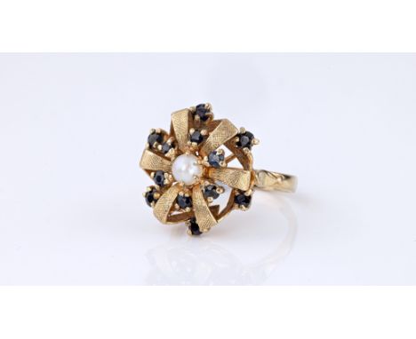 A vintage 9ct yellow gold, sapphire and pearl floral ring, hallmarked London 1967, the six chased petals scattered with round