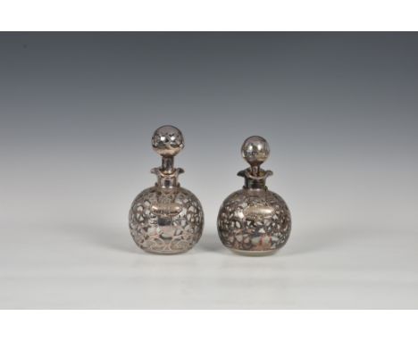 A  matched pair of Edwardian Art Nouveau silver overlay glass decanters, of globular form, both with foliate scrollwork overl