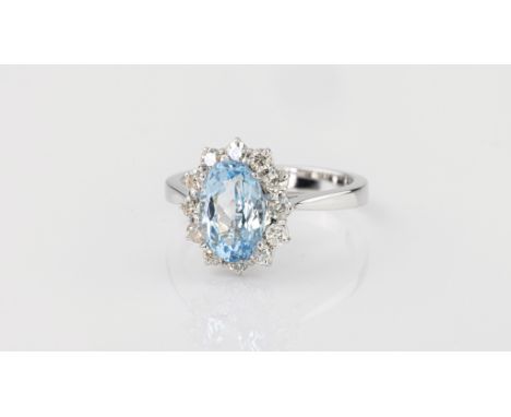 An 18ct white gold, aquamarine and diamond cluster ring, the 1.83ct oval cut aquamarine within a border of twelve brilliant c